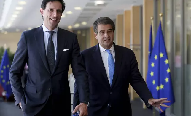 FILE - Designated European Commissioners Wopke Hoekstra, left, and Raffaele Fitto, right, are seen during a first meeting with European Commission President Ursula Von der Leyen in Brussels, Belgium, Sept. 18, 2024. (Olivier Hoslet/Pool Photo via AP, File)