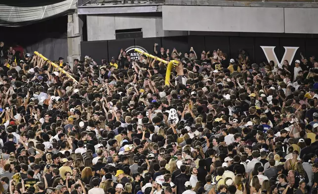 FILE - Vanderbilt fans carry a goalpost around the field after defeating Alabama in NCAA football game on Saturday, Oct. 5, 2024, in Nashville, Tenn. (AP Photo/John Amis, File)