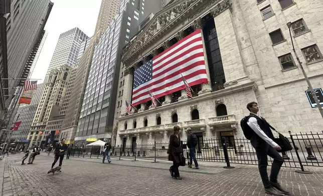 People pass the New York Stock Exchange in New York's Financial District on Tuesday, Nov. 5, 2024. (AP Photo/Peter Morgan)