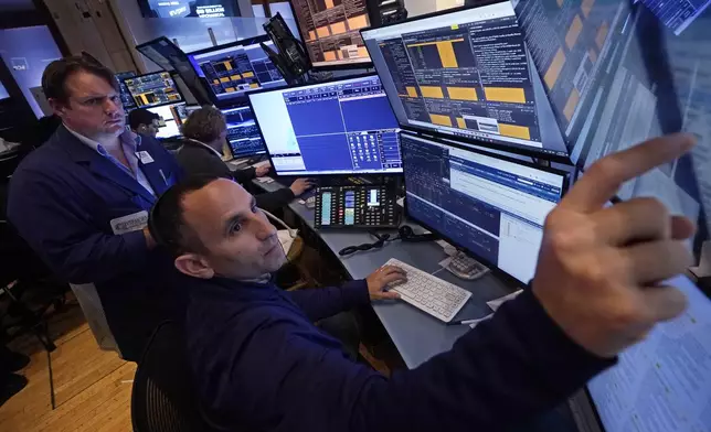 A pair of traders work in their booth on the floor of the New York Stock Exchange, Thursday, Nov. 7, 2024. (AP Photo/Richard Drew)