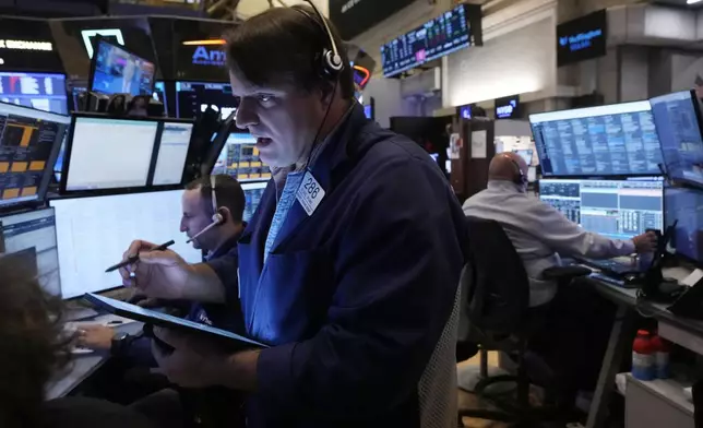 Trader Michael Milano, foreground, works with colleagues on the floor of the New York Stock Exchange, Monday, Nov. 4, 2024. (AP Photo/Richard Drew)