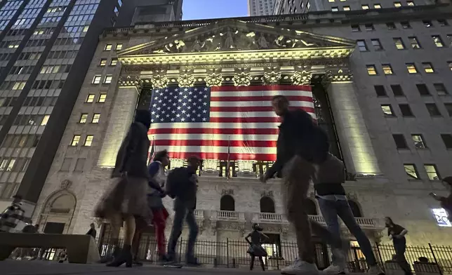 People pass the New York Stock Exchange in New York's Financial District on Tuesday, Nov. 5, 2024. (AP Photo/Peter Morgan)