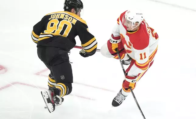 Boston Bruins center Tyler Johnson (90) and Calgary Flames center Mikael Backlund (11) collide in the second period of an NHL hockey game, Thursday, Nov. 7, 2024, in Boston. (AP Photo/Steven Senne)