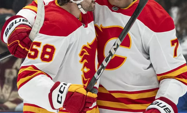 Calgary Falmes' Justin Kirkland, left, celebrates with Kevin Bahl after scoring a goal against the Vancouver Canucks during the first period of an NHL hockey game in Vancouver, British Columbia, Tuesday, Nov. 12, 2024. (Rich Lam/The Canadian Press via AP)