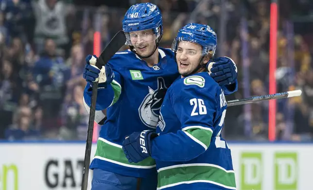 Vancouver Canucks' Erik Brannstrom, right, is congratulated by teammate Elias Pettersson after scoring a goal against the Calgary Flames during third period of an NHL hockey game in Vancouver, British Columbia, Tuesday, Nov. 12, 2024. (Rich Lam/The Canadian Press via AP)