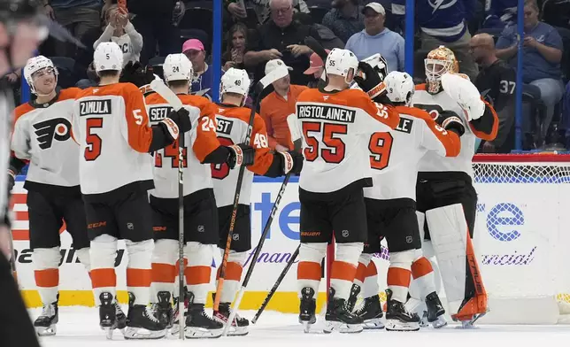 Philadelphia Flyers goaltender Ivan Fedotov (82) celebrates with teammates after the team defeated the the Tampa Bay Lightning during a shootout in an NHL hockey game Thursday, Nov. 7, 2024, in Tampa, Fla. (AP Photo/Chris O'Meara)