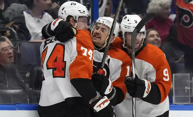 Philadelphia Flyers right wing Owen Tippett (74) celebrates his goal against the Tampa Bay Lightning with right wing Travis Konecny (11) and defenseman Jamie Drysdale (9) during the third period of an NHL hockey game Thursday, Nov. 7, 2024, in Tampa, Fla. (AP Photo/Chris O'Meara)