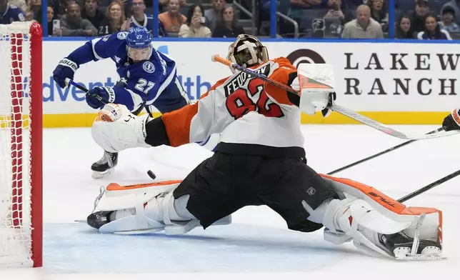 Philadelphia Flyers goaltender Ivan Fedotov (82) stops a shot by Tampa Bay Lightning defenseman Ryan McDonagh (27) during the overtime in an NHL hockey game Thursday, Nov. 7, 2024, in Tampa, Fla. (AP Photo/Chris O'Meara)