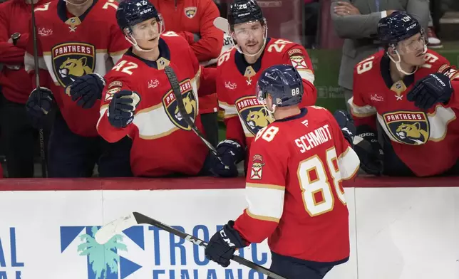 Florida Panthers defenseman Nate Schmidt (88) is congratulated by teammates after he scored during the second period of an NHL hockey game against the Philadelphia Flyers, Saturday, Nov. 9, 2024, in Sunrise, Fla. (AP Photo/Wilfredo Lee)