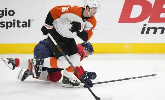 Philadelphia Flyers left wing Joel Farabee (86) and Florida Panthers defenseman Nate Schmidt, rear, battle for the puck during the first period of an NHL hockey game, Saturday, Nov. 9, 2024, in Sunrise, Fla. (AP Photo/Wilfredo Lee)