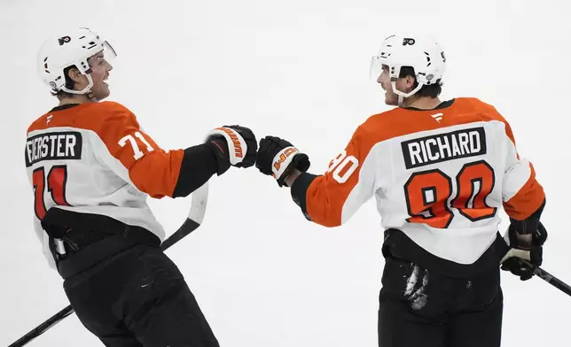 Philadelphia Flyers right wing Tyson Foerster (71) congratulates center Anthony Richard (90) after Richard scored during the second period of an NHL hockey game against the Florida Panthers, Saturday, Nov. 9, 2024, in Sunrise, Fla. (AP Photo/Wilfredo Lee)