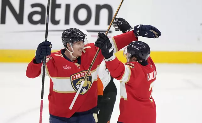 Florida Panthers defenseman Dmitry Kulikov, right, is congratulated by defenseman Niko Mikkola after Kulikov scored during the second period of an NHL hockey game against the Philadelphia Flyers, Saturday, Nov. 9, 2024, in Sunrise, Fla. (AP Photo/Wilfredo Lee)