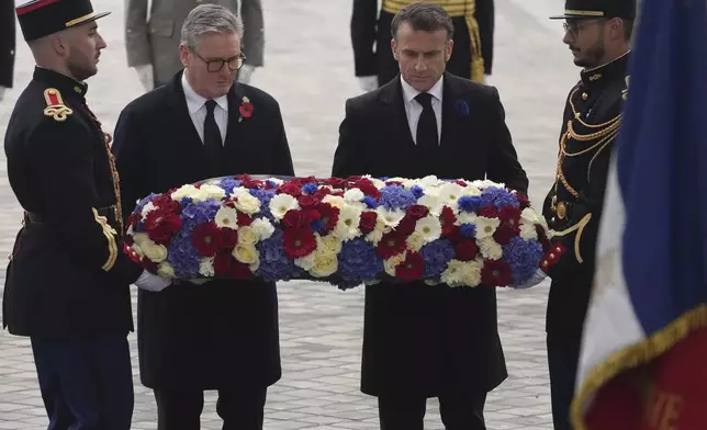 French President Emmanuel Macron, right, and British Prime Minister Keir Starmer lay a wreath during ceremonies marking the 106th anniversary of the Armistice, a celebration of their countries' friendship, as nations across the world pay tribute to their fallen soldiers in World War I, Monday, Nov. 11, 2024 in Paris, (AP Photo/Michel Euler, Pool)