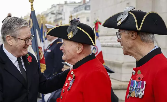 Britain's Prime Minister Keir Starmer greets Chelsea Pensioners during commemorations marking the 106th anniversary of the November 11, 1918, Armistice, ending World War I, at the Arc de Triomphe in Paris, Monday, Nov. 11, 2024. ( Ludovic Marin, Pool via AP)