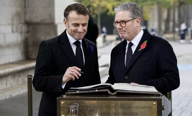 French President Emmanuel Macron, left, and Britain's Prime Minister Keir Starmer sign the Golden Book of the Unknown Soldier during commemorations marking the 106th anniversary of the November 11, 1918, Armistice, ending World War I, in Paris, Monday, Nov. 11, 2024. ( Ludovic Marin, Pool via AP)