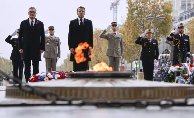 French President Emmanuel Macron, center, and Britain's Prime Minister Keir Starmer stand at attention at the Tomb of the Unknown Soldier during commemorations marking the 106th anniversary of the November 11, 1918, Armistice, ending World War I, in Paris, Monday, Nov. 11, 2024. ( Ludovic Marin, Pool via AP)