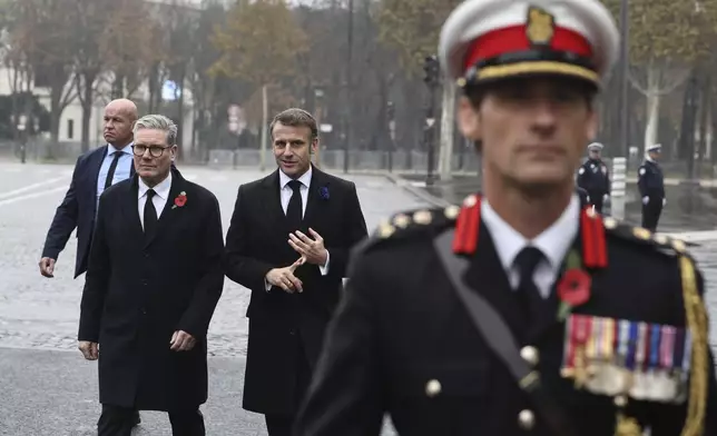 French President Emmanuel Macron, center right, and British Prime Minister Keir Starmer discuss during commemorations marking the 106th anniversary of the WWI Armistice, in Paris, France, Monday, Nov.11 2024. (Christophe Petit Tesson, Pool via AP)