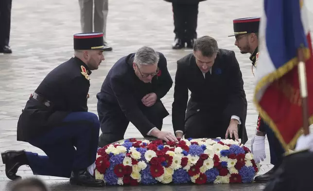 French President Emmanuel Macron, right, and British Prime Minister Keir Starmer, center, lay a wreath during ceremonies marking the 106th anniversary of the Armistice, a celebration of their countries' friendship, as nations across the world pay tribute to their fallen soldiers in World War I, Monday, Nov. 11, 2024 in Paris, (AP Photo/Michel Euler, Pool)