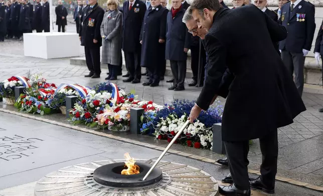 French President Emmanuel Macron, right, and British Prime Minister Keir Starmer revive the flame on the Unknown Soldiers's Tomb under the Arc de Triomphe during commemorations marking the 106th anniversary of the November 11, 1918, Armistice, ending World War I, at the Arc de Triomphe in Paris, Monday, Nov. 11, 2024. ( Ludovic Marin, Pool via AP)