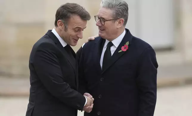 French President Emmanuel Macron, left, welcomes British Prime Minister Keir Starmer Monday, Nov. 11, 2024 at the Elysee Palace in Paris, before ceremonies marking the 106th anniversary of the Armistice, a celebration of their countries' friendship, as nations across the world pay tribute to their fallen soldiers in World War I. (AP Photo/Aurelien Morissard)