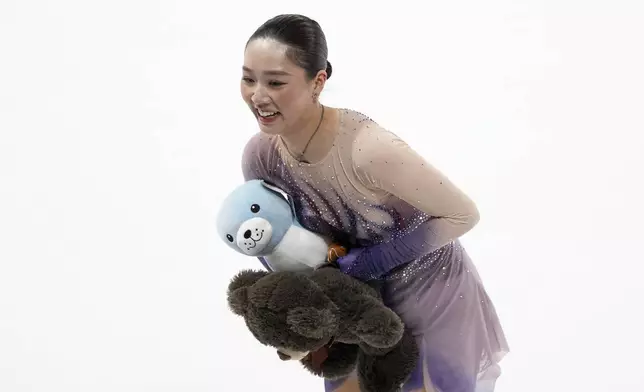 Wakaba Higuchi, of Japan, picks up gifts from fans after competing in the women's free skating segment at the ISU Grand Prix of Figure Skating, Saturday, Nov. 2, 2024, in Angers, France. (AP Photo/Aurelien Morissard)