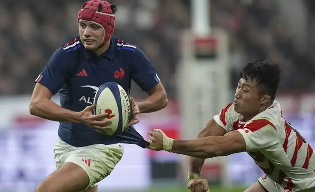 Japan's Tomoki Osada tries to pull back France's Louis Bielle-Biarrey during the Autumn Nations series rugby union match between France and Japan at the Stade de France in Saint-Denis, outside Paris, Saturday, Nov. 9, 2024. (AP Photo/Christophe Ena)