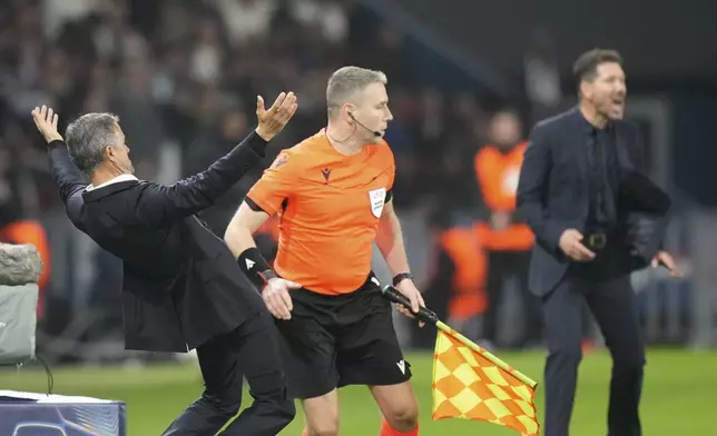 PSG's head coach Luis Enrique, left, and the Atletico Madrid's head coach Diego Simeone react during the Champions League opening phase soccer match between Paris Saint Germain and Atletico Madrid, at the Parc des Princes stadium, in Paris, Wednesday, Nov. 6, 2024. (AP Photo/Michel Euler)