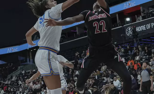 UCLA center Lauren Betts knocks the ball away from Louisville's guard Tajianna Roberts (22) during an NCAA college basketball game Monday, Nov. 4, 2024, in Paris, France. (AP Photo/Aurelien Morissard)