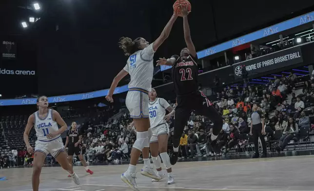 UCLA center Lauren Betts and Louisville's guard Tajianna Roberts (22) battle for the ball during an NCAA college basketball game Monday, Nov. 4, 2024, in Paris, France. (AP Photo/Aurelien Morissard)