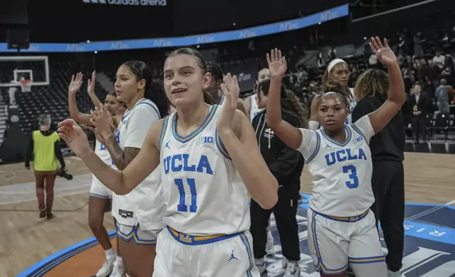 UCLA players celebrate after their victory in an NCAA college basketball game against Louisville, Monday, Nov. 4, 2024, in Paris, France. (AP Photo/Aurelien Morissard)