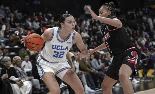 UCLA forward Angela Dugalic, left, controls the ball against Louisville guard Imari Berri, right, during an NCAA college basketball game Monday, Nov. 4, 2024, in Paris, France. (AP Photo/Aurelien Morissard)