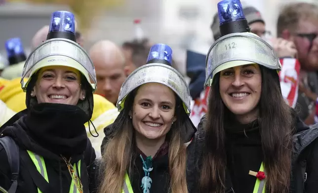 Revelers celebrate at the central Heumarkt while tens of thousands of carnival fools take to the streets of Cologne, Germany, on Monday, November 11, 2024, heralding the official start of the carnival season.(AP Photo/Martin Meissner)