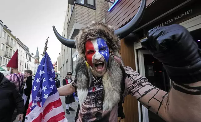 A carnival reveller in a QAnon Shaman - Jacob Chansley costume poses in the Cologne city center while tens of thousands of carnival fools take to the streets of Cologne, Germany, on Monday, November 11, 2024, heralding the official start of the carnival season. (AP Photo/Martin Meissner)