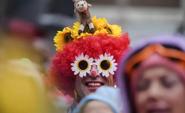 Costumed revelers celebrate at the central Heumarkt while tens of thousands of carnival fools take to the streets of Cologne, Germany, on Monday, November 11, 2024, heralding the official start of the carnival season. (AP Photo/Martin Meissner)