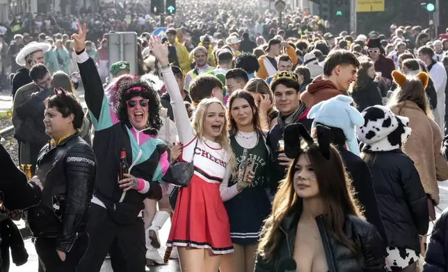 Revelers celebrate at the overcrowded Zuelpicher neighborhood while tens of thousands of carnival fools take to the streets of Cologne, Germany, on Monday, Nov. 11, 2024, heralding the official start of the carnival season. (AP Photo/Martin Meissner)