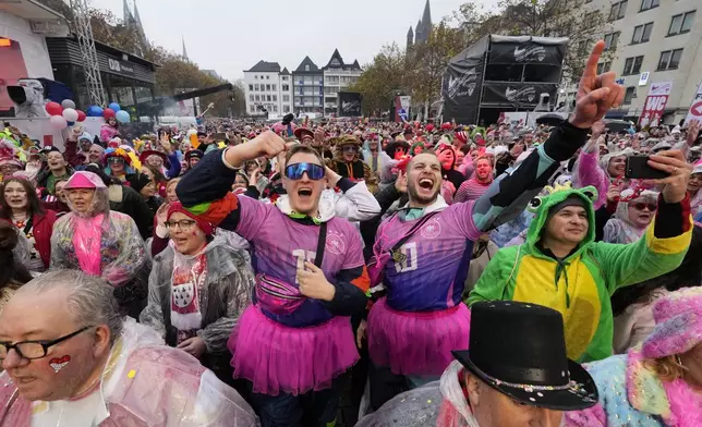 Costumed revelers celebrate at the central Heumarkt while tens of thousands of carnival fools take to the streets of Cologne, Germany, on Monday, November 11, 2024, heralding the official start of the carnival season.(AP Photo/Martin Meissner)