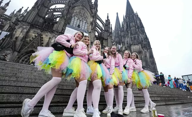 Costumed revelers pose in front of there Cologne Cathedral while tens of thousands of carnival fools take to the streets of Cologne, Germany, on Monday, November 11, 2024, heralding the official start of the carnival season. (AP Photo/Martin Meissner)