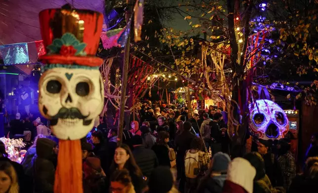 People attend a ceremony of the Day of the Dead in Berlin, Friday, Nov. 1, 2024. (AP Photo/Ebrahim Noroozi)