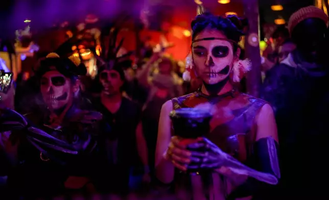 A Mexican Azteca dance group performs during the Day of the Dead ceremony in Berlin, Germany, Friday, Nov. 1, 2024. (AP Photo/Ebrahim Noroozi)