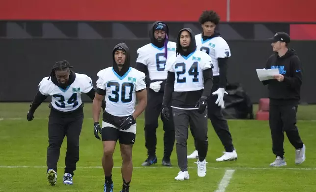 Carolina Panthers running back Chuba Hubbard (30) and Carolina Panthers running back Jonathon Brooks (24) warm up with team mates for a practice session in Munich, Germany, Friday, Nov. 8, 2024. The Carolina Panthers are set to play the New York Giants in an NFL game at the Allianz Arena in Munich on Sunday Nov. 10. (AP Photo/Matthias Schrader)