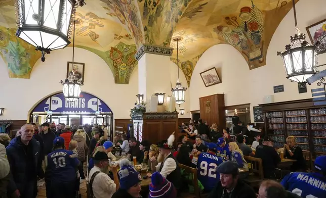 New York Giants supporters enjoy the day inside the traditional 'Hofbraeuhaus' in Munich, Germany, Saturday, Nov. 9, 2024 ahead of the NFL match between the Carolina Panthers and the New York Giants in Munich on Sunday. (AP Photo/Matthias Schrader)