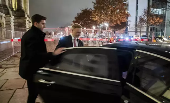 Federal Minister of Finance Christian Lindner, right, gets into his limousine in front of the Reichstag building after his dismissal by the Federal Chancellor Olaf Scholz and a parliamentary group meeting in Berlin, Wednesday, Nov. 6, 2024. (Christoph Soeder/dpa via AP)