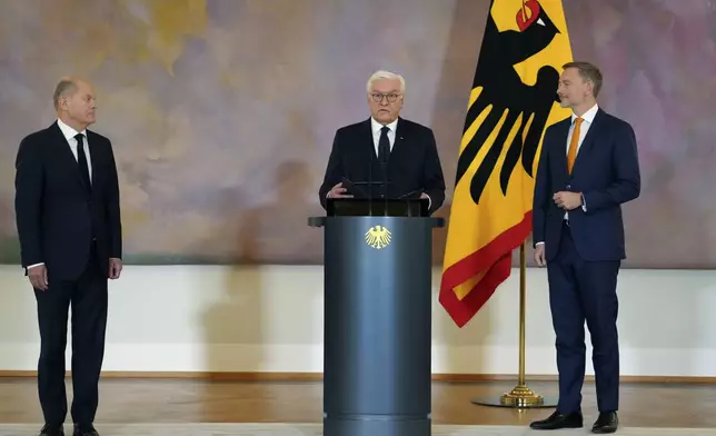 Germany's Federal President Frank-Walter Steinmeier, center, presents Christian Lindner, former Federal Minister of Finance, right, with his certificate of dismissal with German Chancellor Olaf Scholz, at left, at Bellevue Palace, in Berlin, Thursday, Nov. 7, 2024. (Kay Nietfeld/dpa via AP)