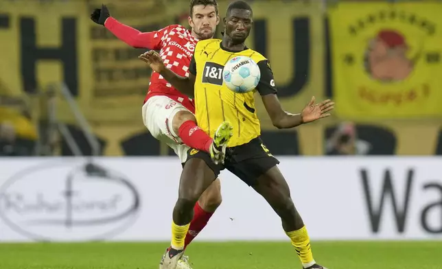 Mainz's Stefan Bell and Dortmund's Serhou Guirassy, right, challenge for the ball during the German Bundesliga soccer match between 1. FSV Mainz 05 and Borussia Dortmund in Mainz, Germany, Saturday, Nov. 9, 2024. (Thomas Frey/dpa via AP)