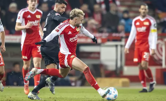 Freiburg's Vincenzo Grifo, second from left, and Berlin's Benedict Hollerbach, centre, fight for the ball during the German Bundesliga soccer match between FC Union Berlin and SC Freiburg in Berlin, Friday, Nov. 8, 2024. (Andreas Gora/dpa via AP)