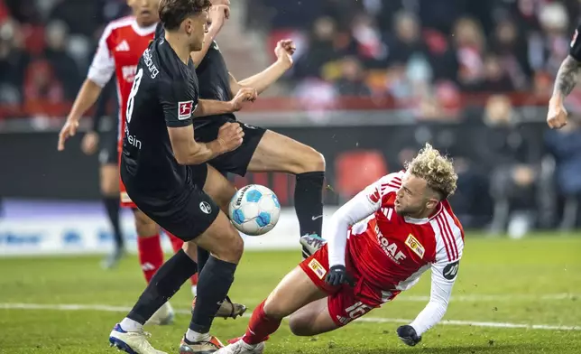 Freiburg's Maximilian Eggestein, left, and Berlin's Benedict Hollerbach fight for the ball during the German Bundesliga soccer match between FC Union Berlin and SC Freiburg in Berlin, Friday, Nov. 8, 2024. (Andreas Gora/dpa via AP)