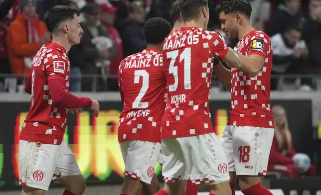 Mainz's scorer Paul Nebel, left, and his teammates celebrate their side's third goal during the German Bundesliga soccer match between 1. FSV Mainz 05 and Borussia Dortmund in Mainz, Germany, Saturday, Nov. 9, 2024. (Thomas Frey/dpa via AP)