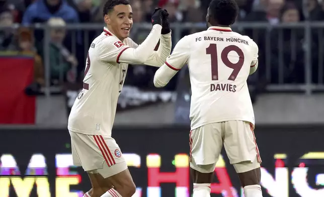 Munich's scorer Jamal Musiala, left, and his teammate Alphonso Davies, right, celebrate the opening goal during the German Bundesliga soccer match between FC St. Pauli and FC Bayern Munich in Hamburg, Germany, Saturday, Nov. 9, 2024. (Christian Charisius/dpa via AP)