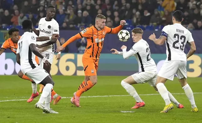 Shakhtar's Oleksandr Zubkov, centre, challenges for the ball with Young Boys' Lewin Blum during the Champions League opening phase soccer match between Shakhtar Donetsk and Young Boys Bern at the Arena AufSchalke in Gelsenkirchen, Germany, Wednesday, Nov. 6, 2024. (AP Photo/Martin Meissner)