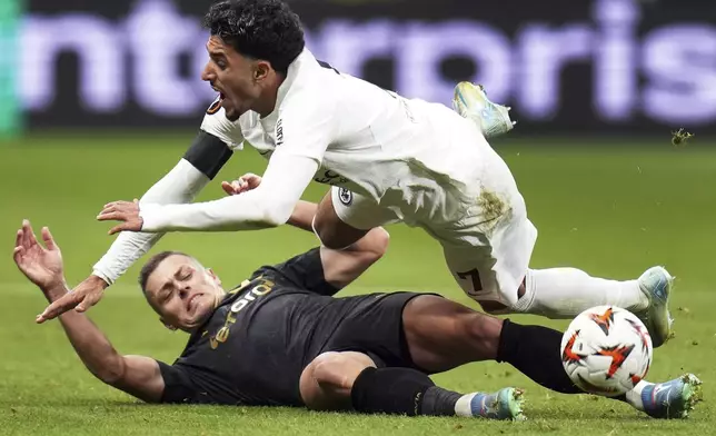 Prague's Tomas Holes, bottom, and Frankfurt's Omar Marmoush, top, challenge for the ball during the Europa League opening phase soccer match between Eintracht Frankfurt and Slavia Prague in Frankfurt, Germany, Thursday, Nov. 7, 2024. (Thomas Frey/dpa via AP)